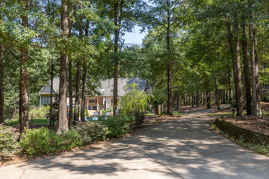 View from Guest bungalow driveway pad of Homeowners house. Approx 300ft away. Plenty of trees and shrubs offer extra privacy. Guest bungalow has its own drive way that diverts off to the left, once inside property fence line.