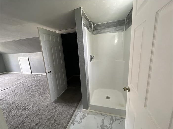 upper level space/bedroom with a queen size bed and a dresser