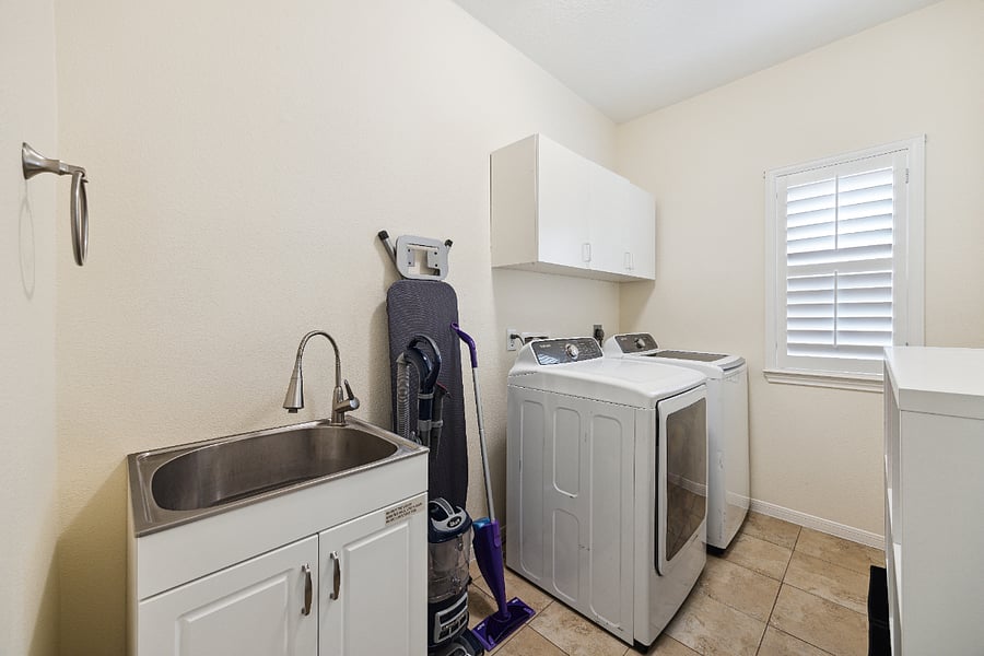 Fully equipped laundry room with washer/dryer, iron/ironing board and sink