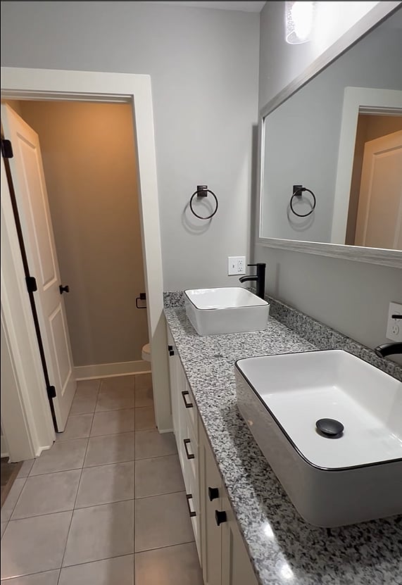Main bathroom double vanity and closed door toilet room.