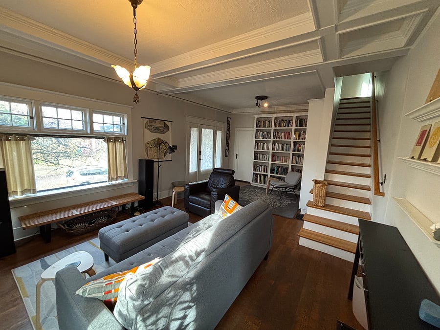 Main floor living room, front door entrance and stairs to upper level bedrooms, office and bathroom.