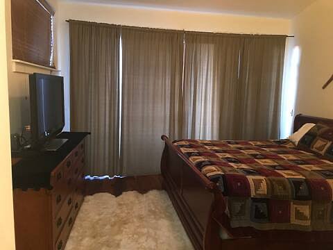Larger Bedroom with dresser and Smart TV