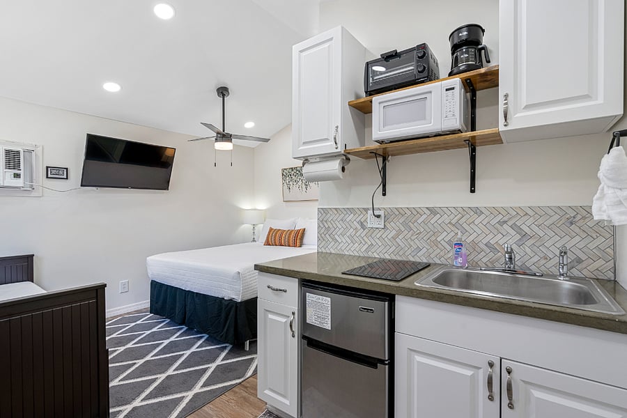 The space features a pull-out daybed, queen bed, bathroom, and kitchen.