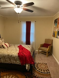 master bedroom features queen bed and fold and go crib in closet