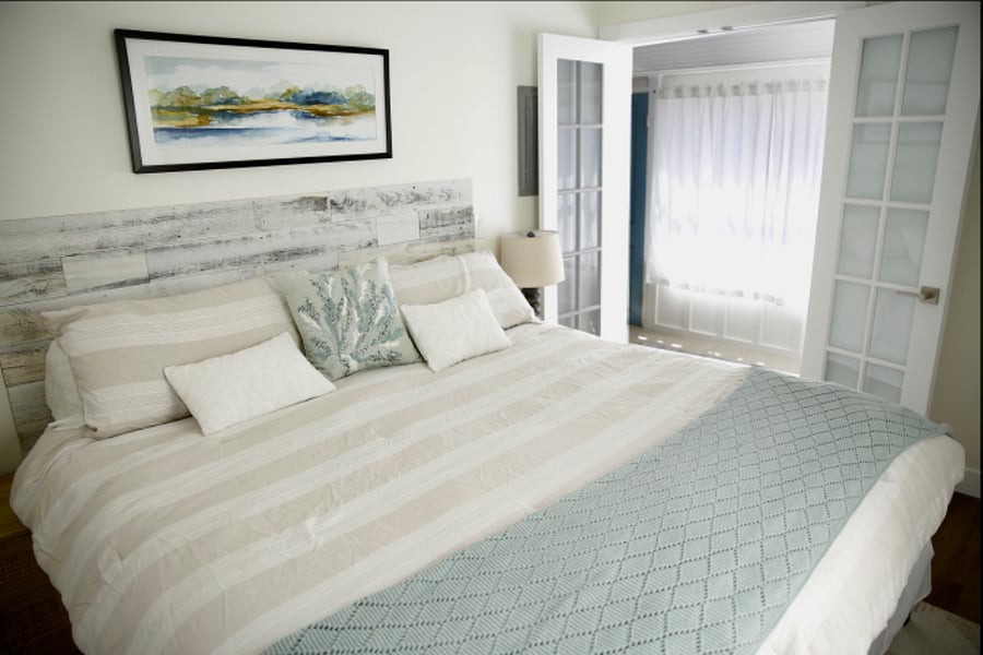 Master bedroom with king-sized bed and dresser in closet.