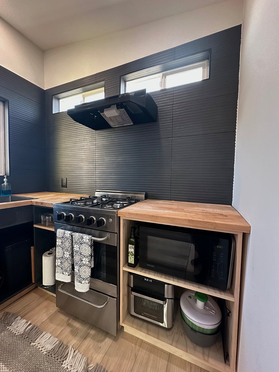 This kitchen was recently updated top to bottom with a beautiful modern porcelain tile backsplash that is simple to clean. Weve also installed a gas stove with 4 burners and a microwave surrounded by beautifully refinished butcher block giving plenty of counter space.