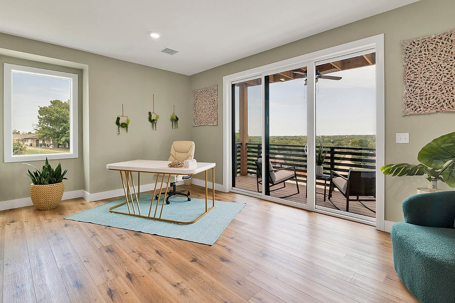A bright work area featuring an oversized desk and executive chair, conveniently located near the balcony for fresh air and inspiration.