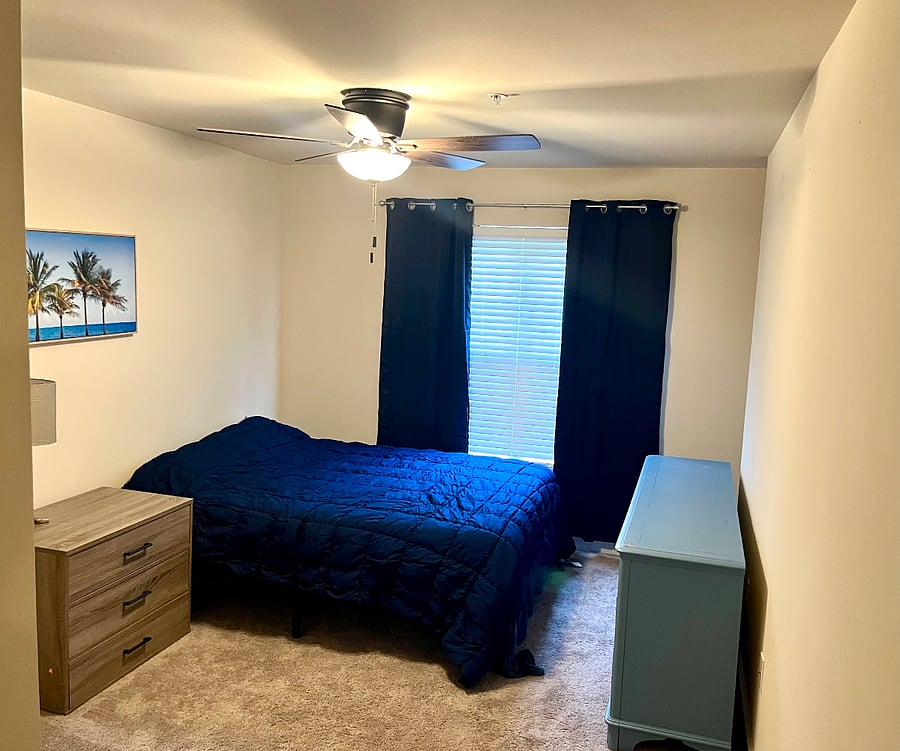 Larger guest bedroom with queen bed, nice sized closet and large long dresser with TV