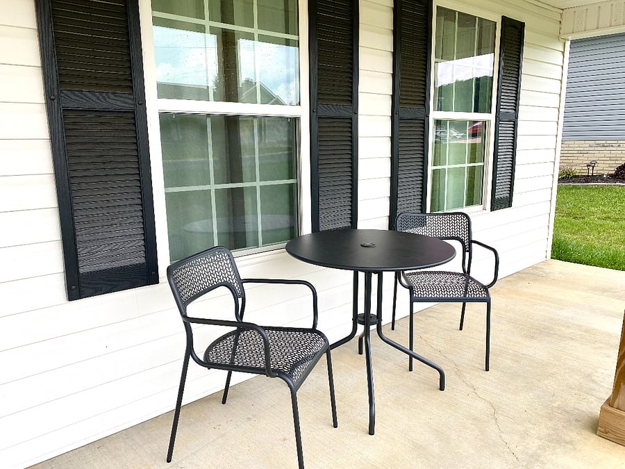Covered front porch seating and table.