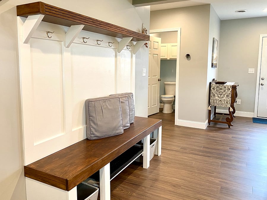 Coat rack, bench, storage, and shoe area near entry.