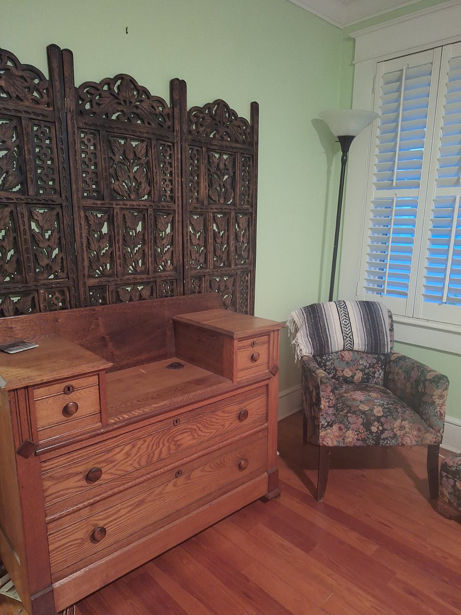 Master Bedroom vanity and chair next to window.