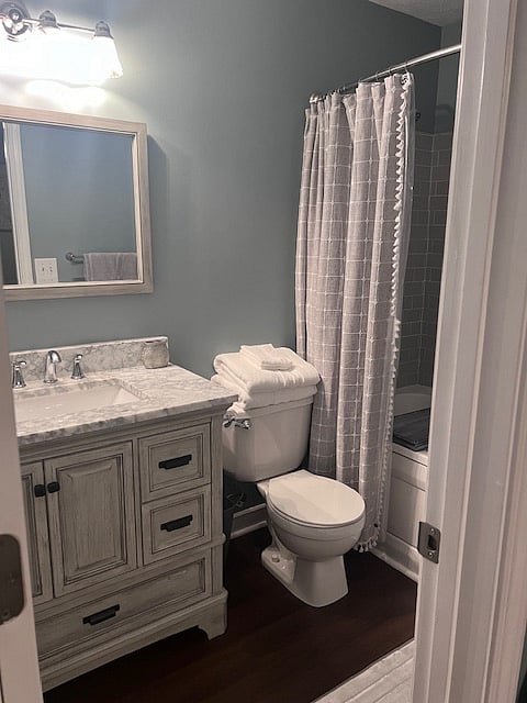 Master bath with gray subway tile surrounding whirlpool tub. Marble top sink. Hair dryer in bottom drawer. TP provided.