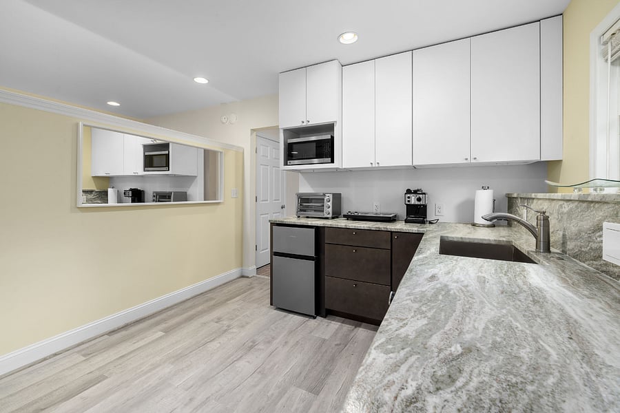 Kitchenette with lots of cabinets, hot plate for cooking, toaster oven, coffee maker, small fridge and freezer
