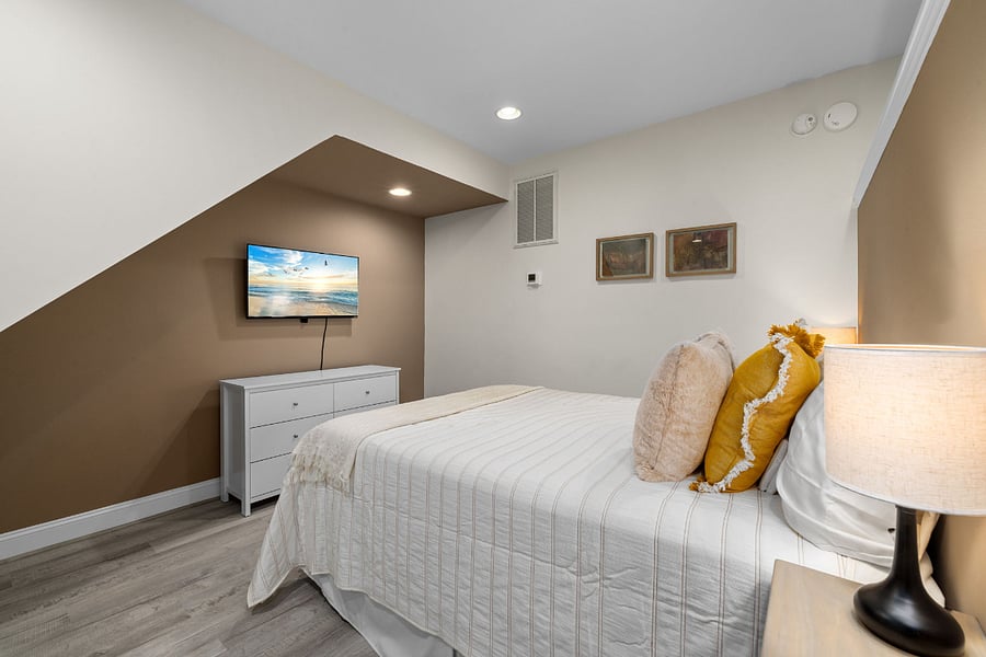 Queen bed with dresser and TV