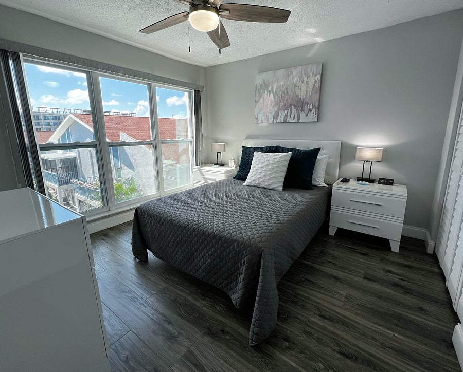 Guest bedroom with room darkening shades, a queen bed, closet, and a smart TV