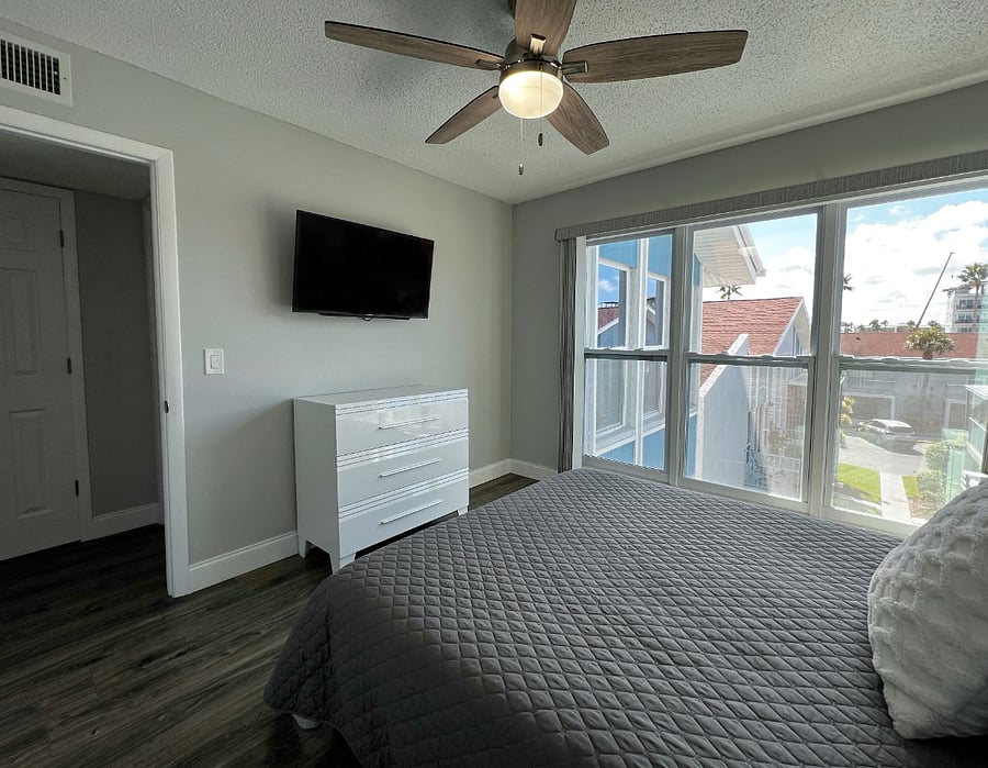 Guest bedroom with room darkening shades, a queen bed, closet, and a smart TV