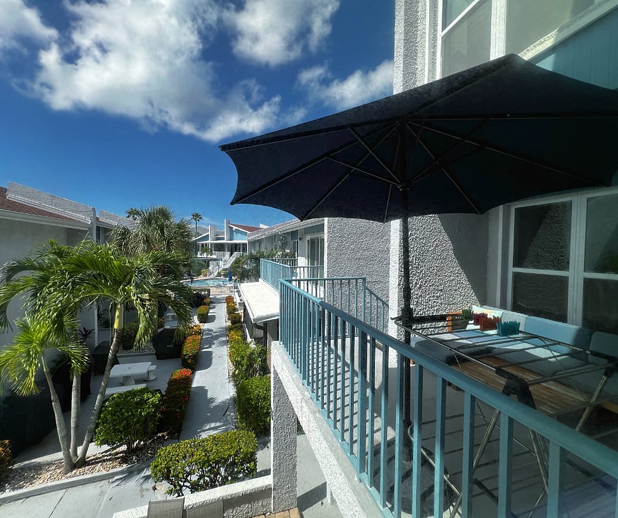 View of the balcony and pool from the living room of the condo.