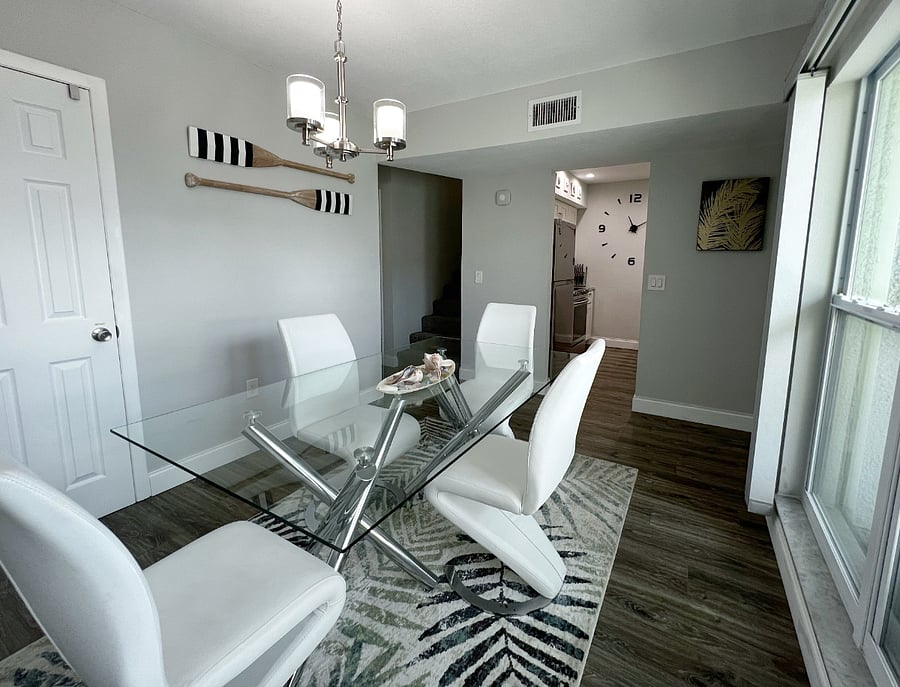 Dining room with view of the kitchen and the stairs.
