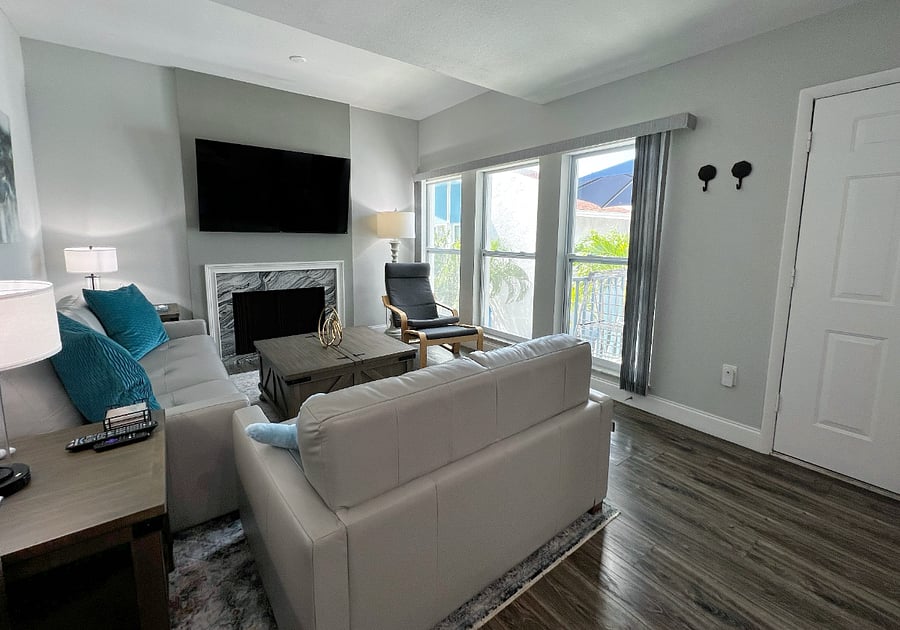 Front entrance door and view of the comfortable living room with a large smart TV