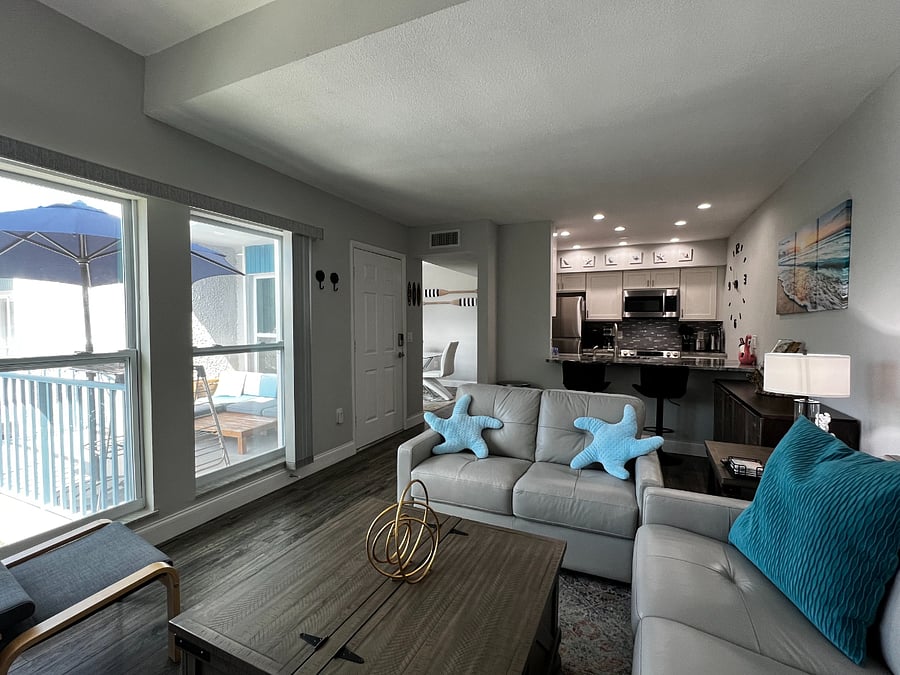 View of the living room facing the entry door and open kitchen.