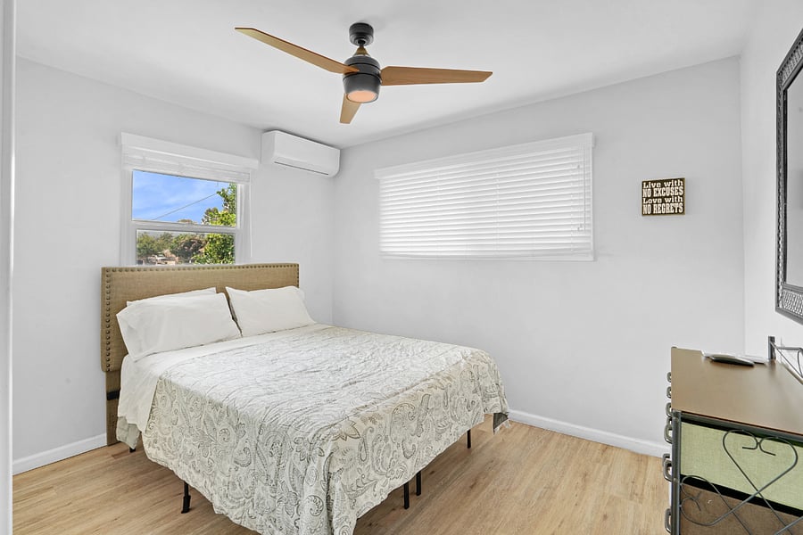 Bedroom One (1) with air-conditioning, ceiling fan, and lots of natural sunlight