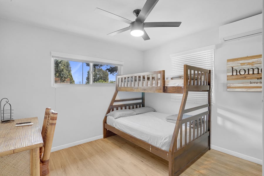 Bedroom One (3) with air-conditioning, ceiling fan, dedicated work desk, and lots of natural sunlight