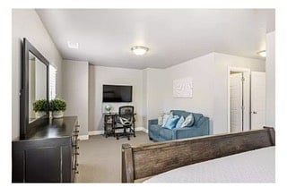 sitting area in master bedroom with desk and couch