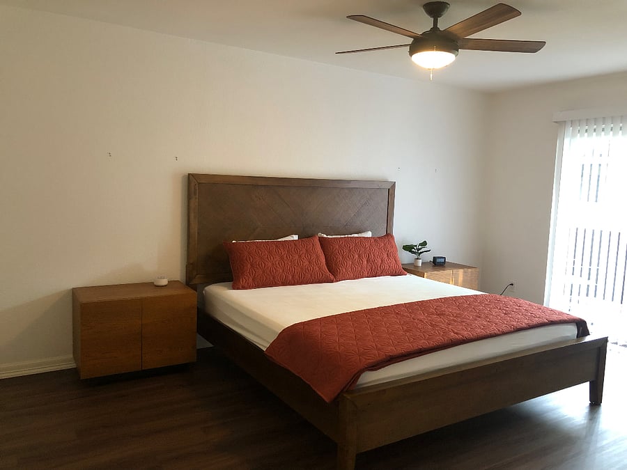 Spacious Master bedroom with King size bed, dresser, and desk in room.
