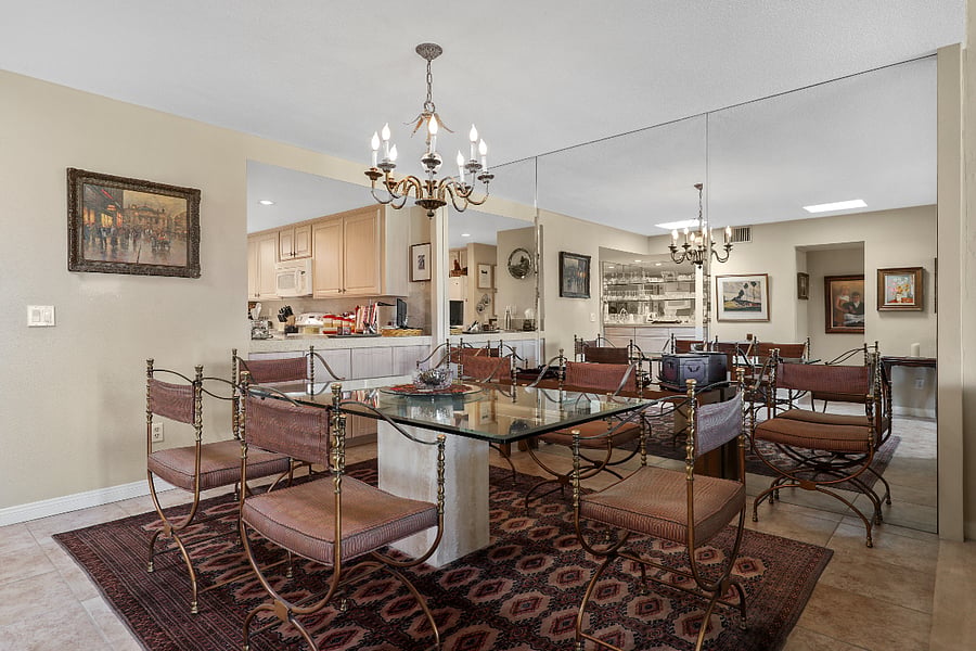 Dining room w/ wall of mirrors and interior breakfast bar to kitchen.