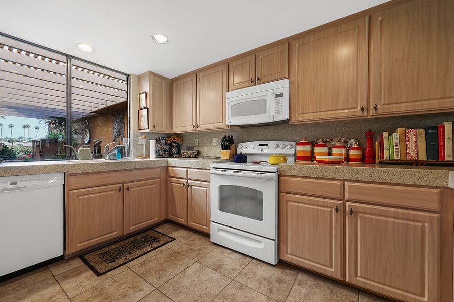 Quartz counters and backsplash, updated appliances and view to front patio.