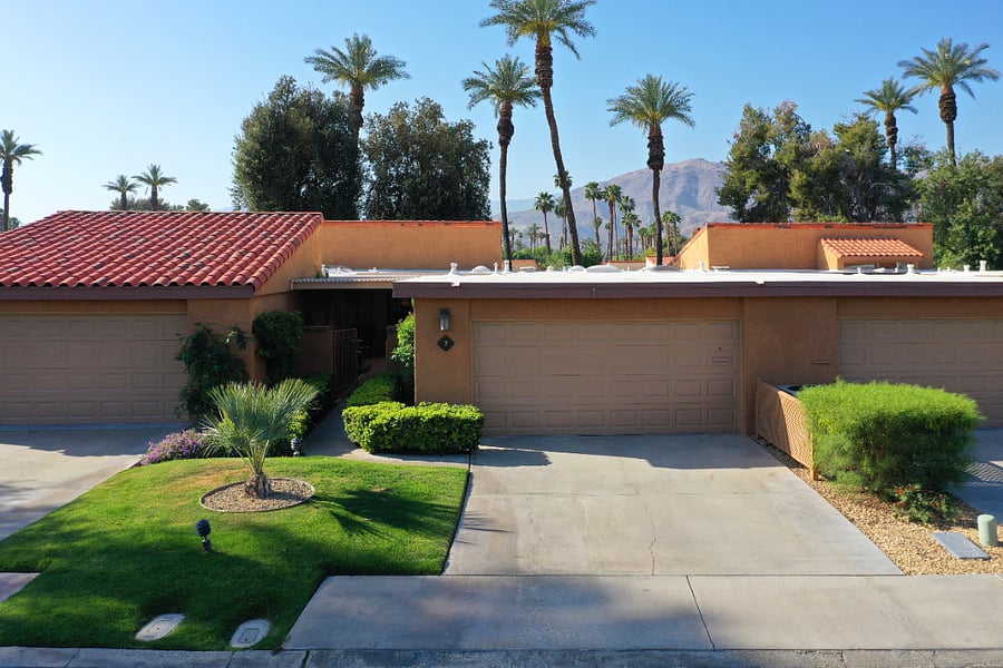 Exterior front w/ two car wide driveway w/ mountain views to the rear.