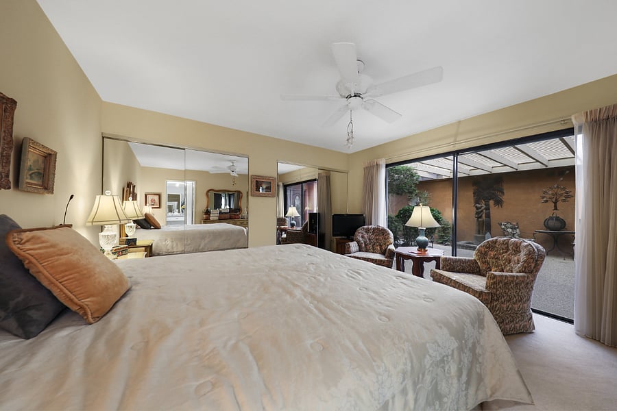 Main bedroom w/ mirrored wall of closets & wall of glass doors to front patio.