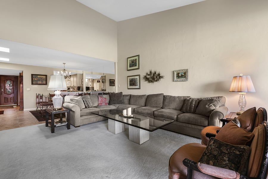 Living room w/ vaulted ceilings looking to dining room and kitchen pass through.