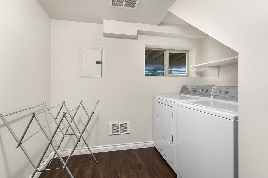 In unit laundry with dry rack and additional storage and cabinets not shown.