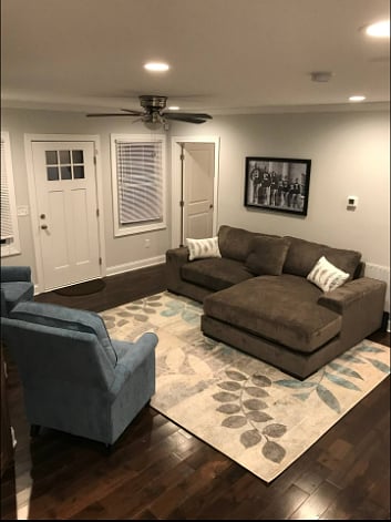 Front door opens into the living room with plush chaise couch and 2 reclining arm chairs.