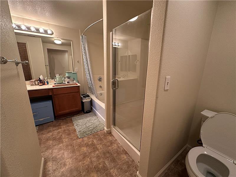 Within the bathroom there is a tea/coffee station, a mini fridge, and a sealed trash container.