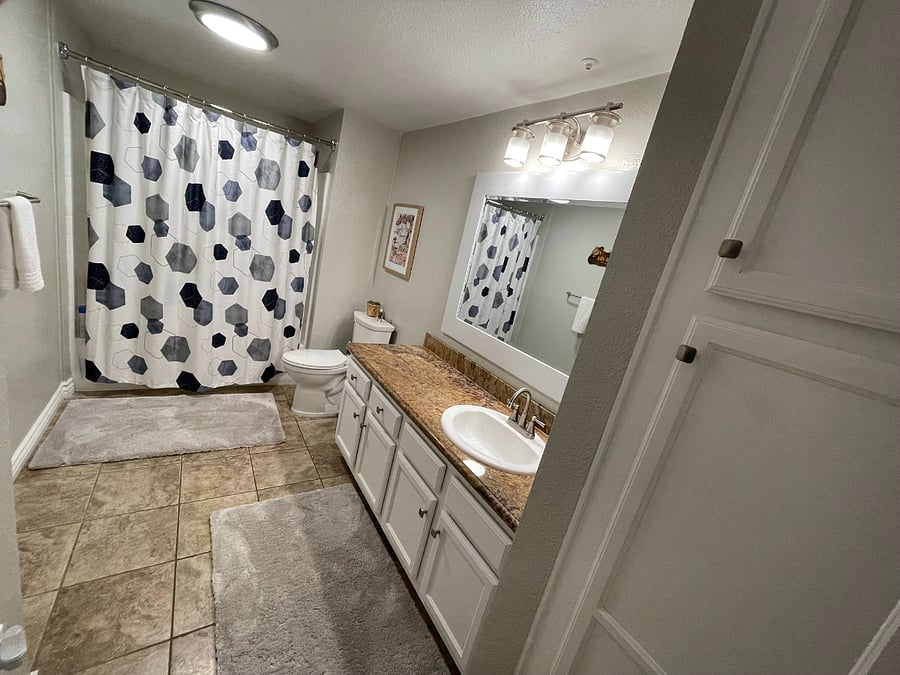 Large bathroom with linen closet and plenty of under-counter storage.