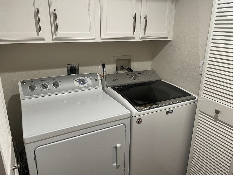 Laundry closet with two cabinets. Iron board, iron and clothes drying rack.