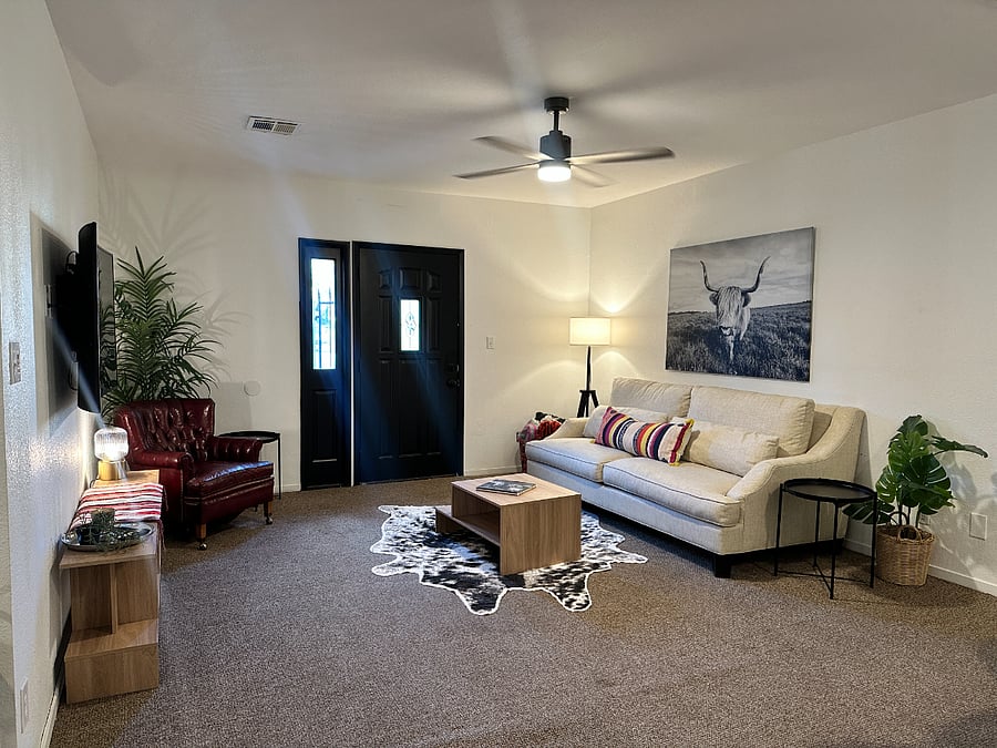 TV room with couch and fan.