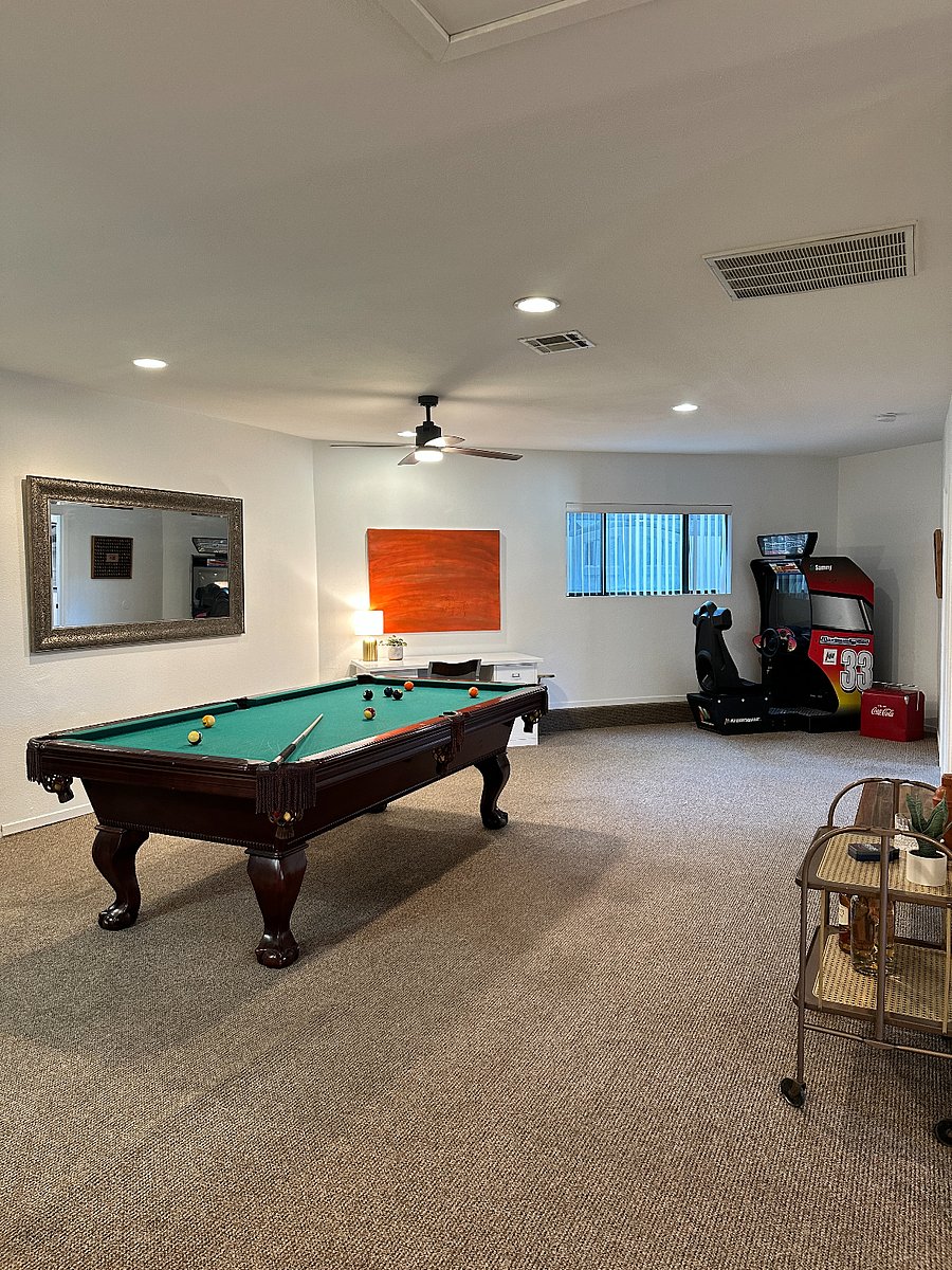 Entertainment area with pool table, work desk, and vintage video game.