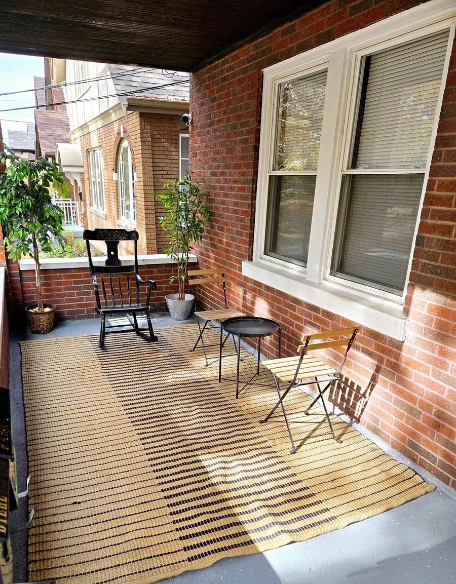 Porch patio furniture and rocking chair with carpet and plants