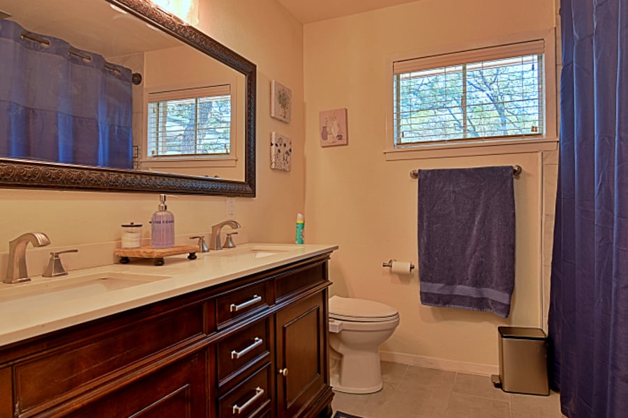 The guest bathroom features a relaxing tub and a refreshing rain shower