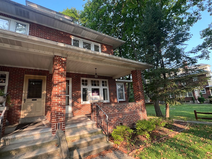 Front of house with porch and security cameras. Smart lock on front door. Keyless entry