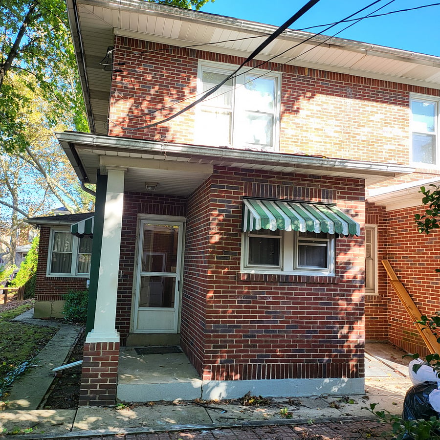 Back of house with patio and security cameras.