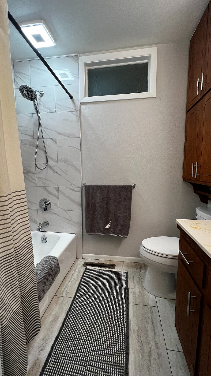 Upstairs hall bathroom with tub/shower combo and upgraded exhaust fan with built-in Bluetooth speaker.