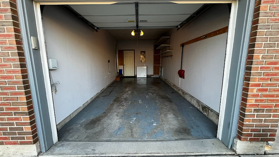 Single-car garage with chest deep freezer and baby gear for guest convenience.