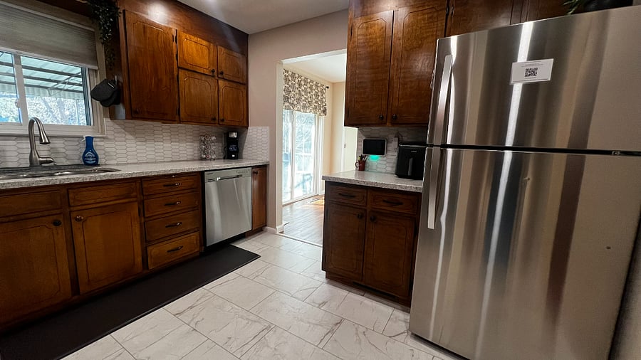 Alternate kitchen view showing the open flow to the dining area and backyard patio access.
