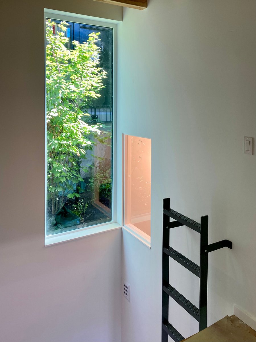 High window in double height space provides natural light to back of studio and bathroom. Motorized blind provides privacy.