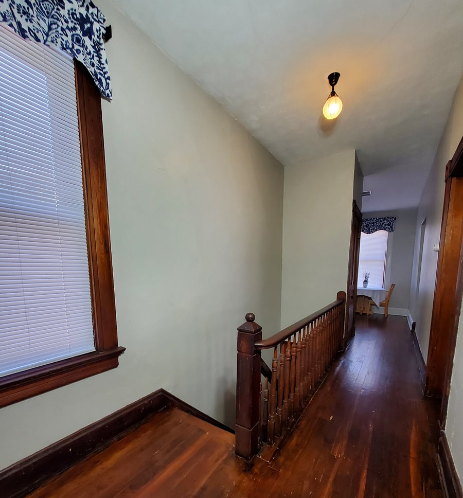 The stairway and hallway, looking toward the breakfast nook. Not sure if the light fixture is original, but it is unusual and beautiful!