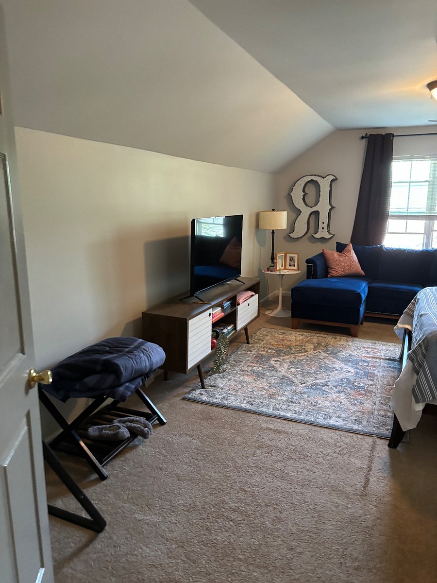 TV and luggage rack in queen bedroom room